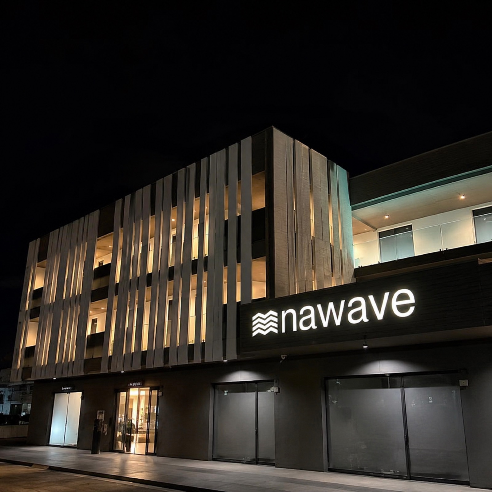 La sede Nawave di sera con l'insegna illuminata